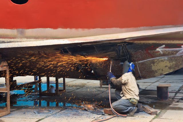 Man welding a boat, manufacturing